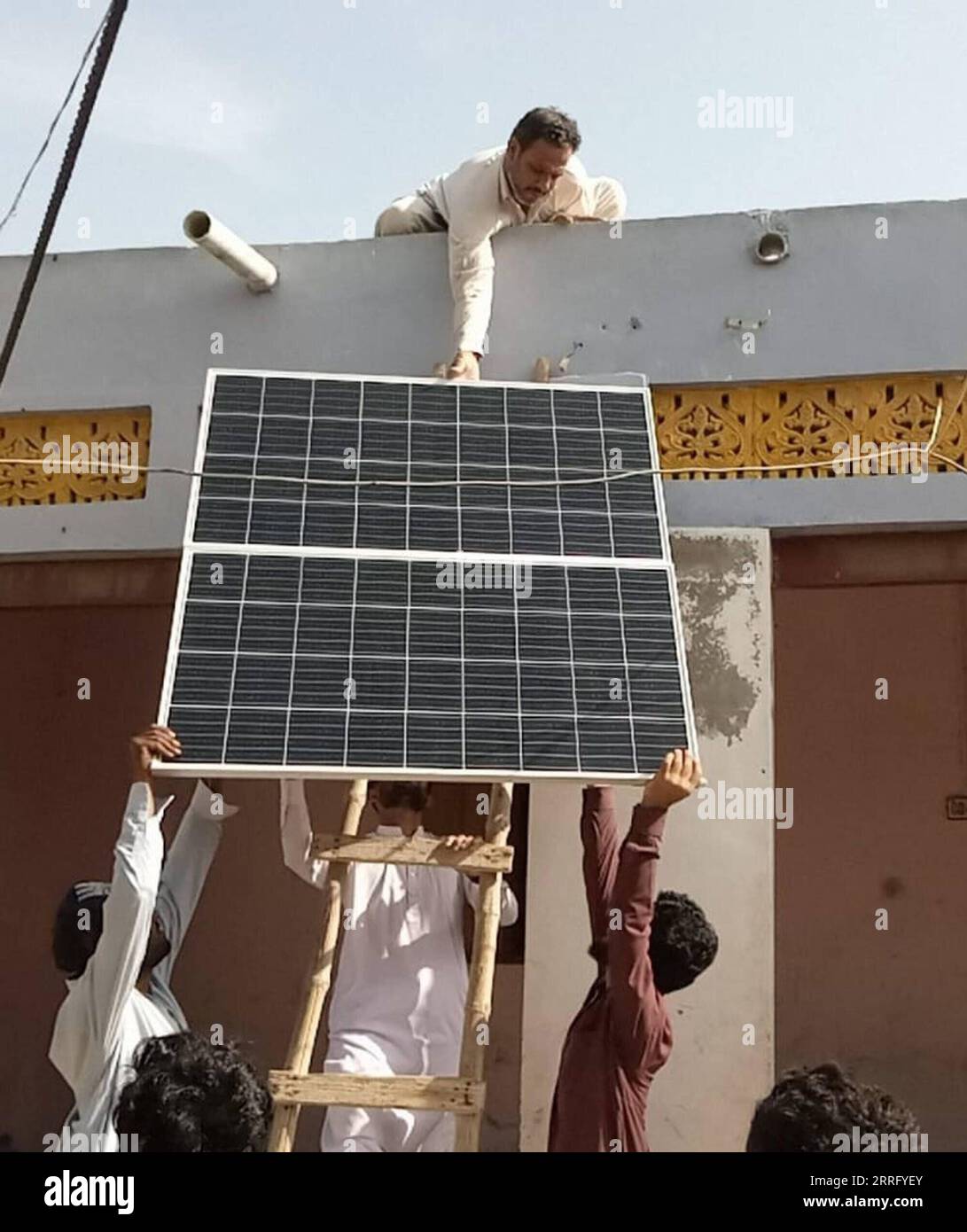 220430 -- GWADAR, April 30, 2022 -- Workers install a China-donated solar panel at a house in Gwadar, Pakistan, March 14, 2022. TO GO WITH Feature: Chinese aid illuminates houses, helps fishermen in Pakistan s Gwadar Str/Xinhua PAKISTAN-GWADAR-CHINA-AID-SOLAR SYSTEM Stringer PUBLICATIONxNOTxINxCHN Stock Photo