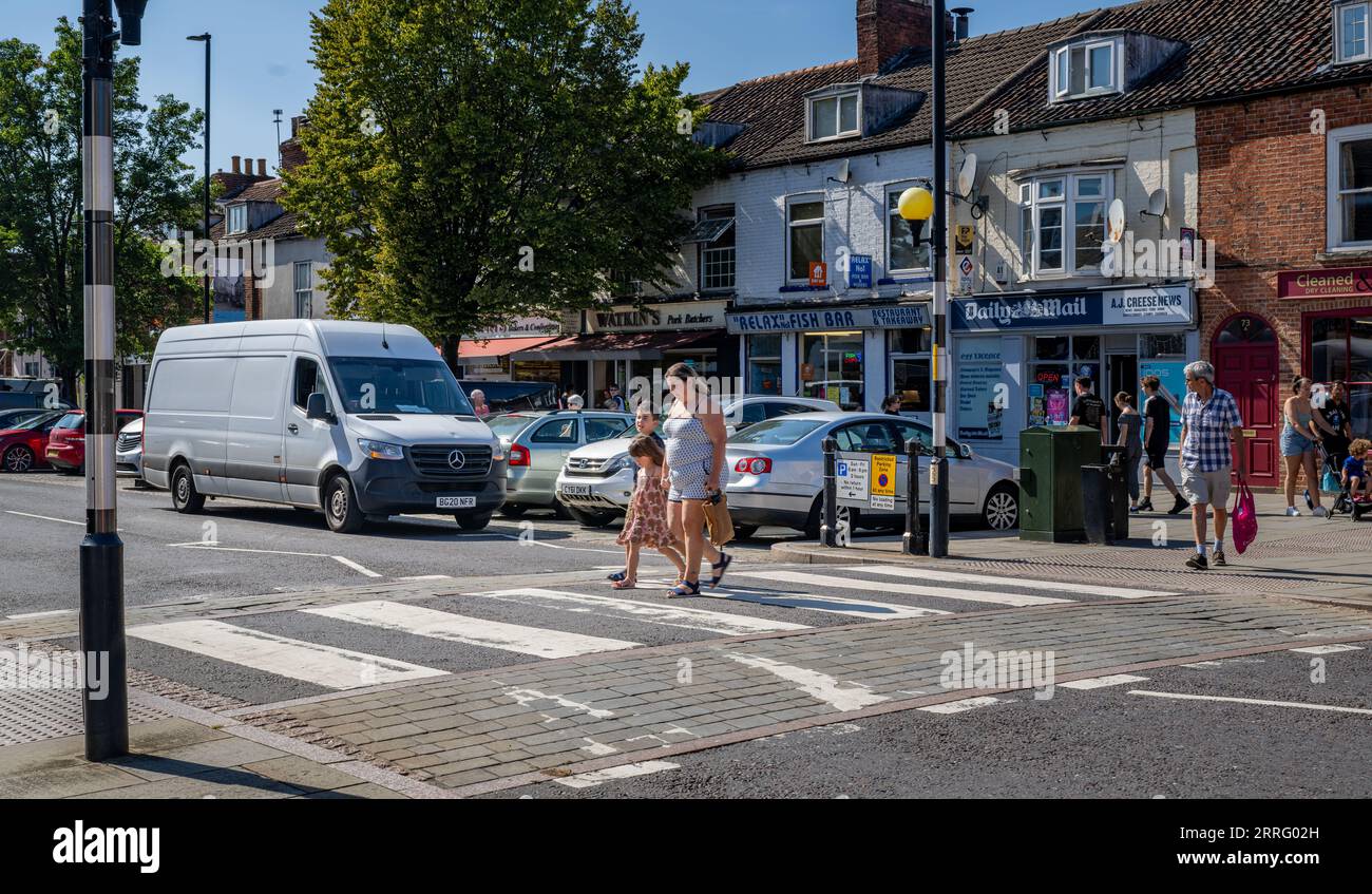 Grantham Lincolnshire - Zebra crossing or a pedestrian crossing on a very busy street with a young mother and children crossing Stock Photo