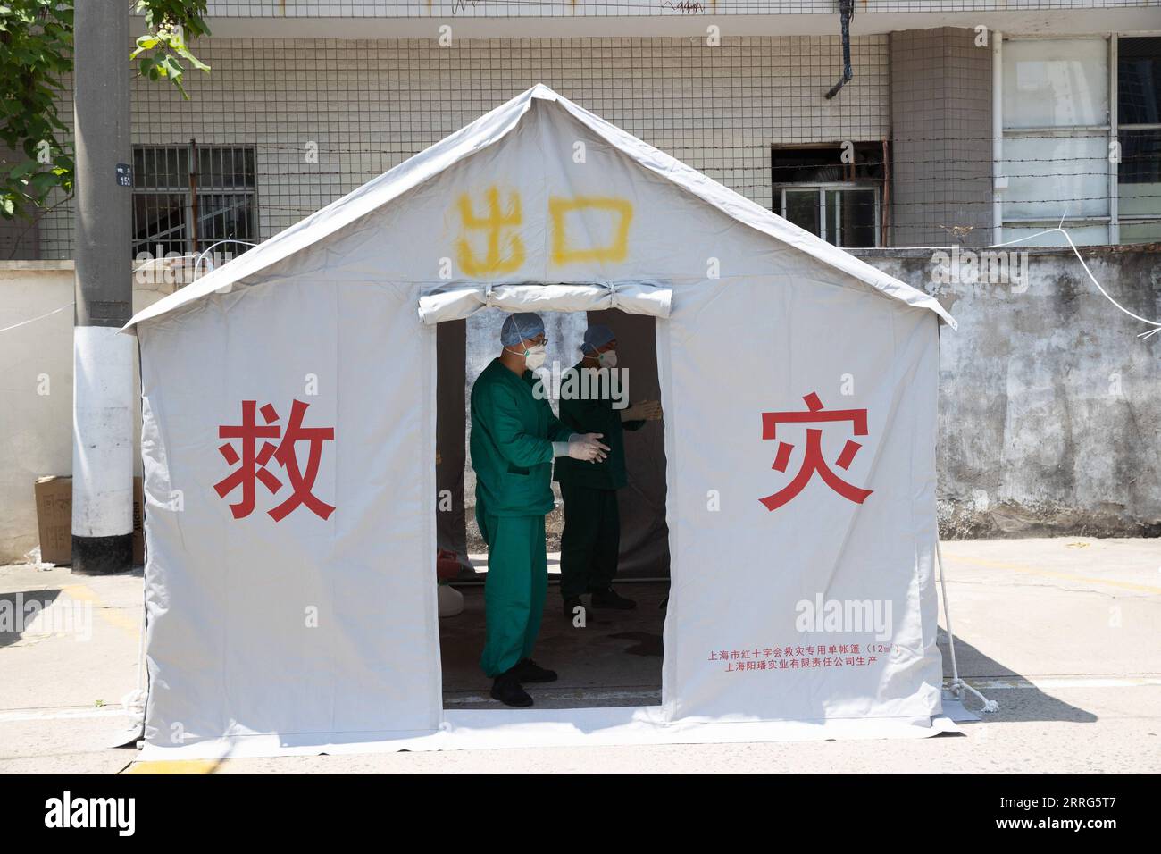 220510 -- SHANGHAI, May 10, 2022 -- Meng Xiangjun L and Zhang Zhimin conduct disinfection after taking off protective suits near the headquarters of a medical emergency team in east China s Shanghai, May 9, 2022. A medical emergency team consisting of 108 members with 50 ambulances from north China s Tianjin has arrived at Shanghai to assist in the city s public medical emergency service amid the COVID-19 resurgence.  CHINA-SHANGHAI-MEDICAL TEAM-COVID-19-AID CN JinxLiwang PUBLICATIONxNOTxINxCHN Stock Photo