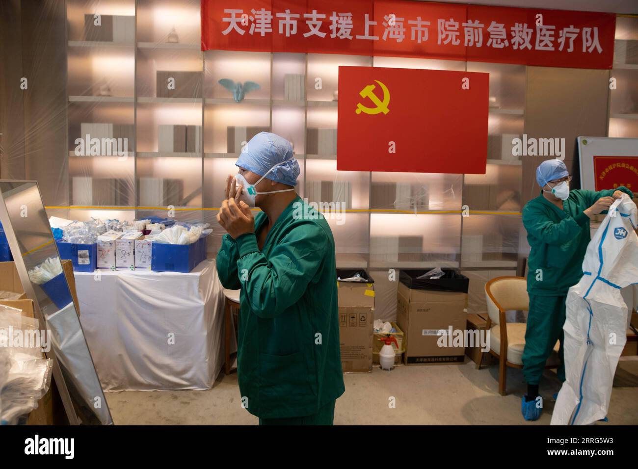 220510 -- SHANGHAI, May 10, 2022 -- Meng Xiangjun and Zhang Zhimin L wear protective suits at the headquarters of a medical emergency team on Caoyang Road in east China s Shanghai, May 9, 2022. A medical emergency team consisting of 108 members with 50 ambulances from north China s Tianjin has arrived at Shanghai to assist in the city s public medical emergency service amid the COVID-19 resurgence.  CHINA-SHANGHAI-MEDICAL TEAM-COVID-19-AID CN JinxLiwang PUBLICATIONxNOTxINxCHN Stock Photo