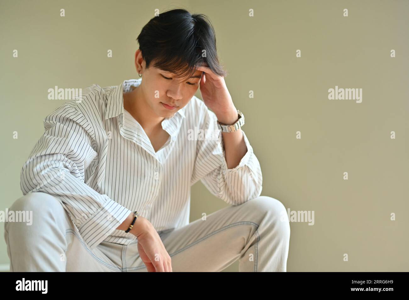 Unhappy young man holding his head, suffering from depression. Loneliness, depression, mental heath concept Stock Photo
