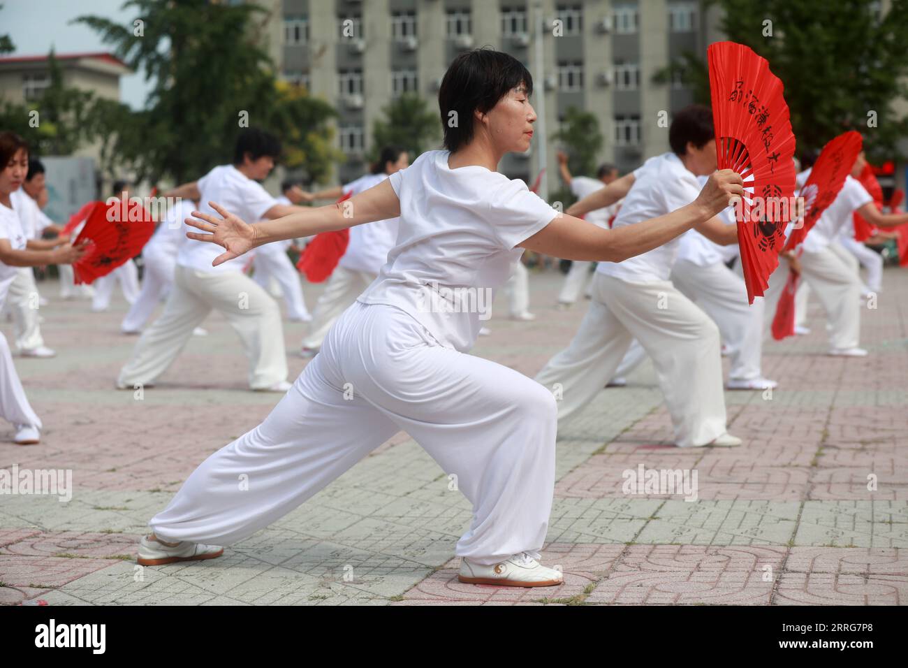 LUANNAN COUNTY, Hebei Province, China - August 8, 2020: People are practicing Tai Chi fans in the square Stock Photo