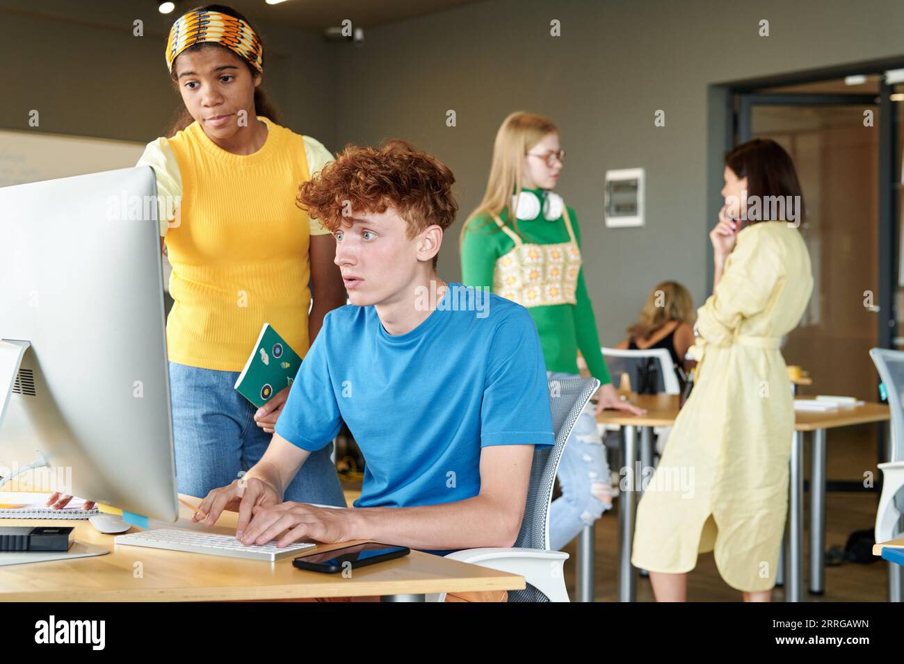 Schoolboy typing on computer and discussing new software with his ...