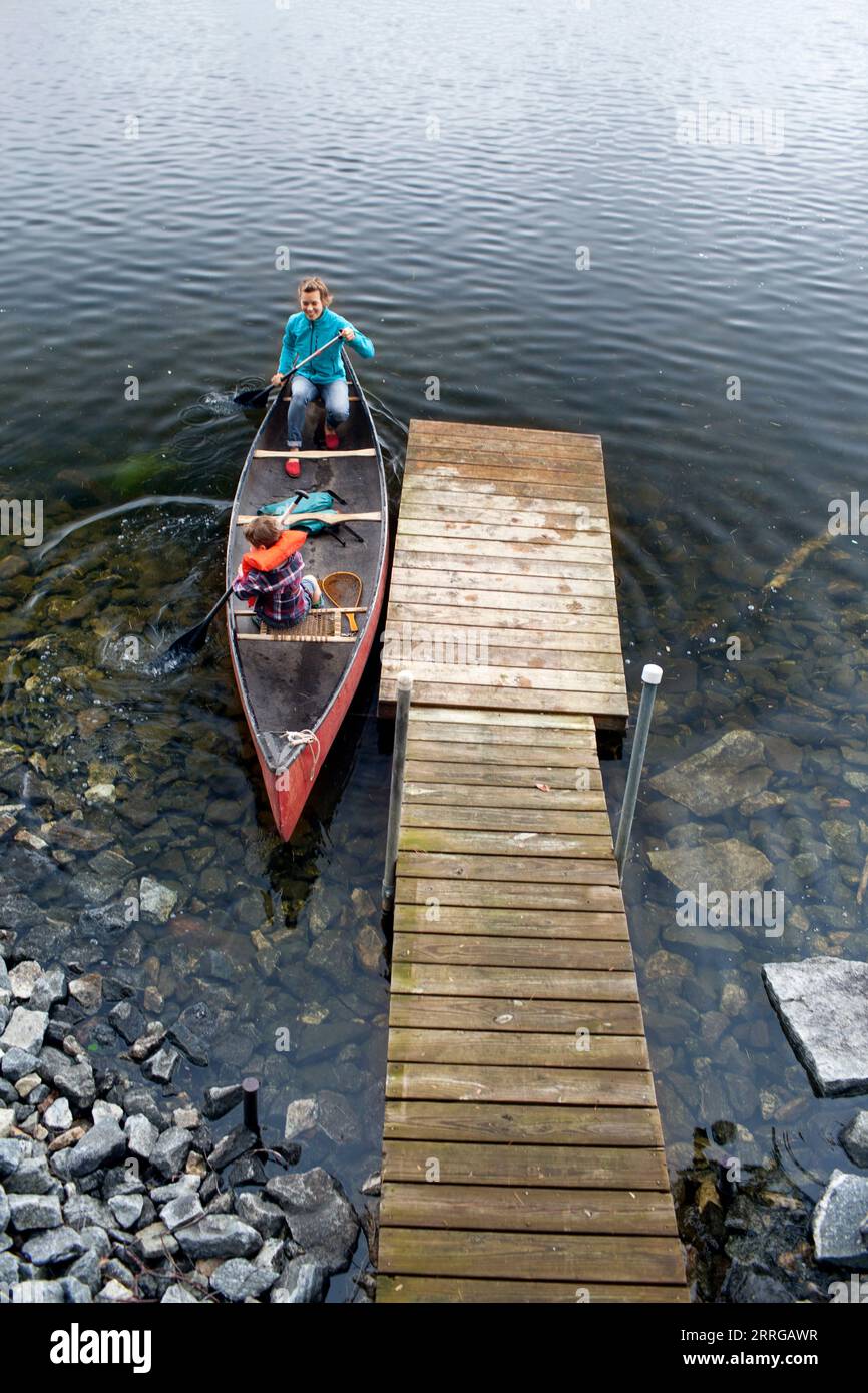 Mother and young son push away from dock at Kezar Lake Stock Photo