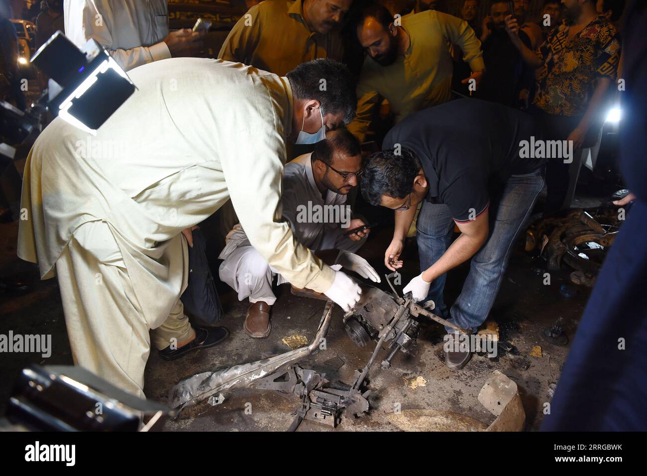 220516 -- KARACHI, May 16, 2022 -- Security personnel examine the blast site in Karachi, Pakistan, on May 16, 2022. A bomb went off in Pakistan s southern port city of Karachi on Monday, leaving at least 13 people injured including policemen, police officials said. Str/Xinhua PAKISTAN-KARACHI-BLAST Stringer PUBLICATIONxNOTxINxCHN Stock Photo