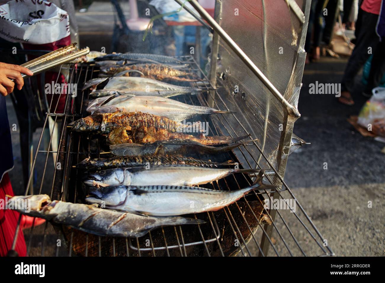 Grilled fish on hot stove at street market Stock Photo