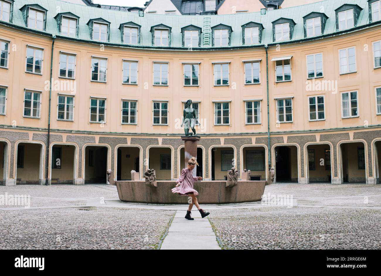 girl dancing in front a beautiful building in Gamla Stan, Stockholm Stock Photo