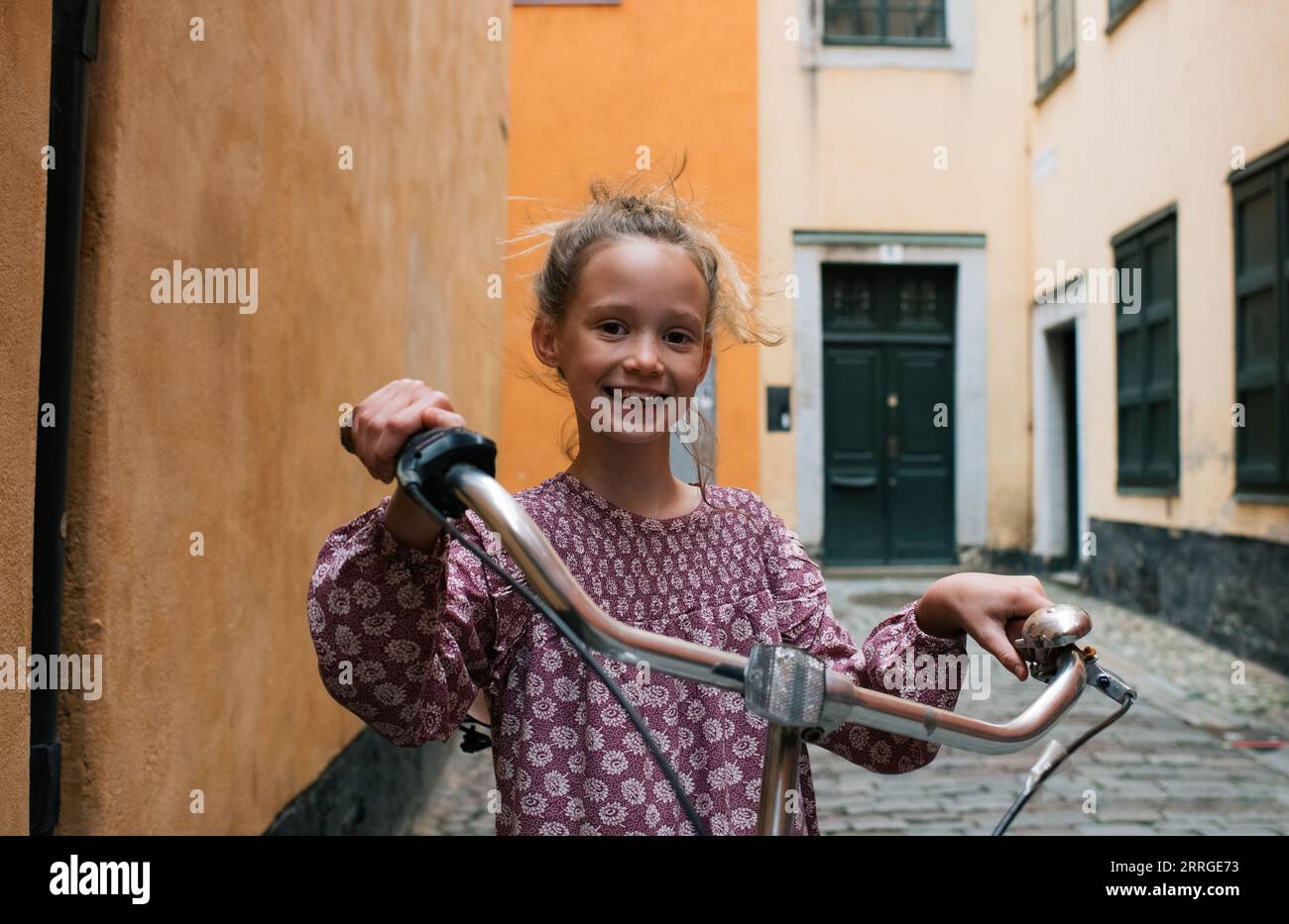 child holding a bike in the Gamla Stan, Stockholm Stock Photo