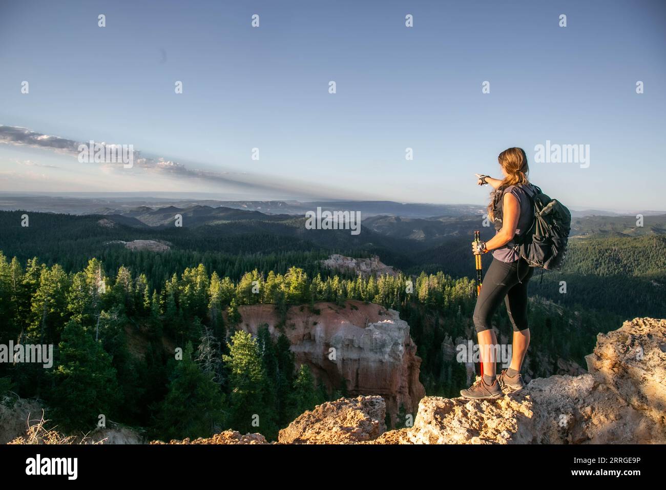 A woman in athletic clothing points to the horizon Stock Photo