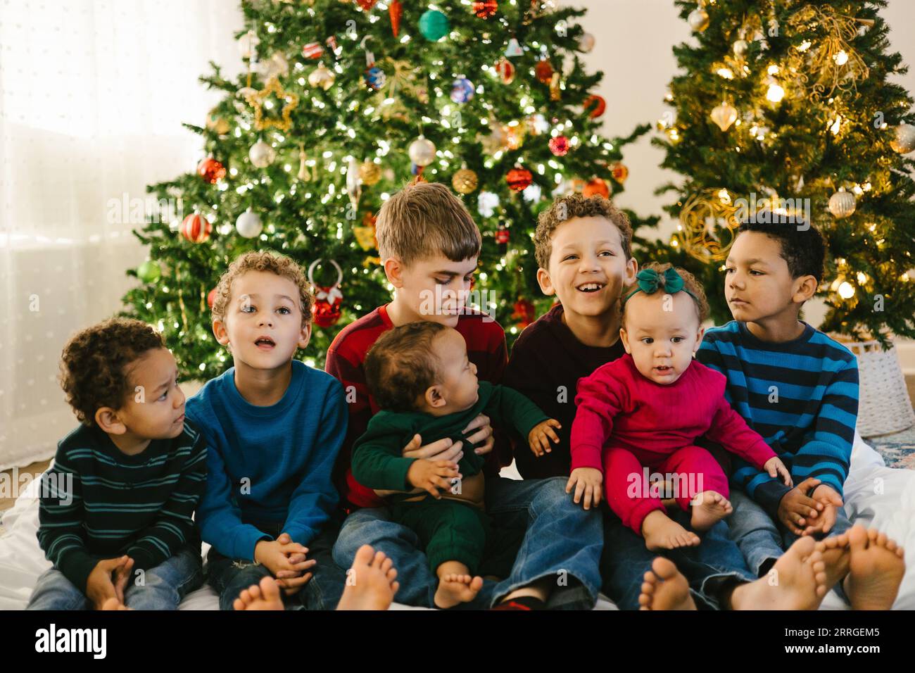 Diverse large family with lots of children in front of christmas tree Stock Photo