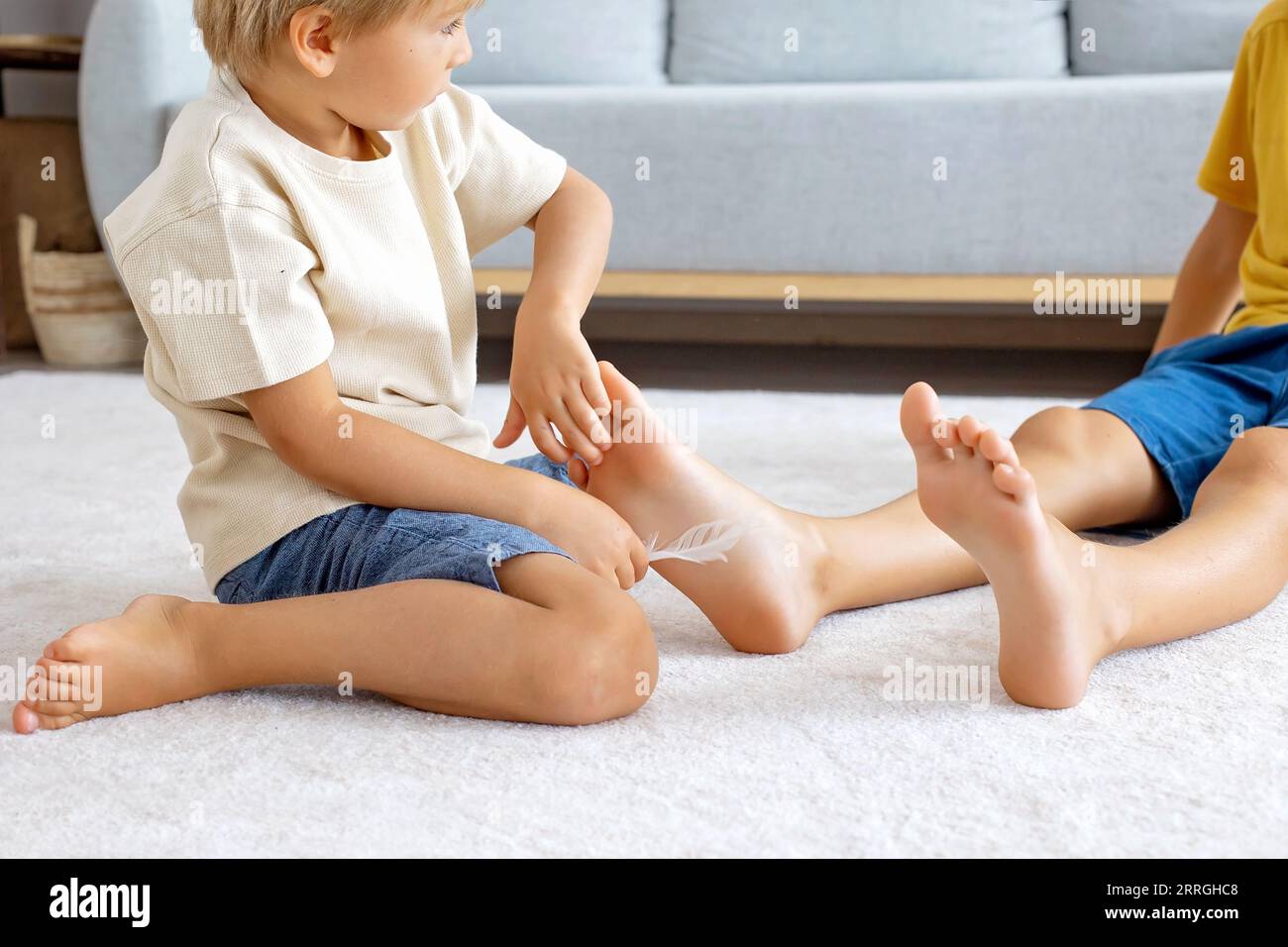 Happy positive children, tickling on the feet, having fun together, boy bro...