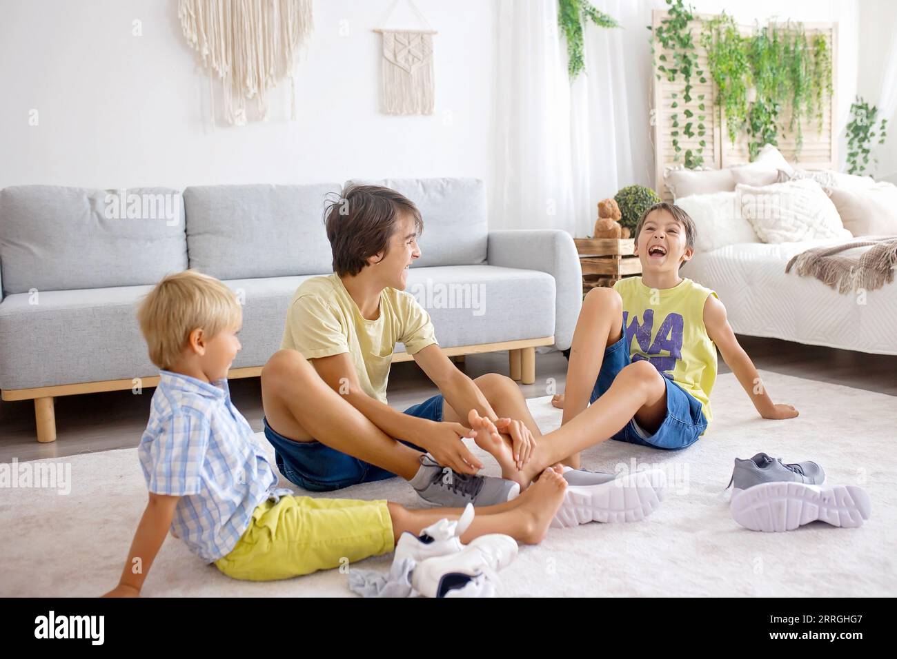 Happy positive children, tickling on the feet, having fun together, boy