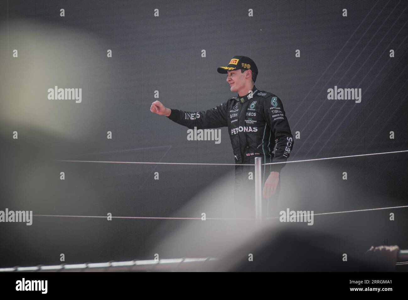 George Russell stands at the podium, reveling in his third-place finish at the Spanish Grand Prix. Stock Photo