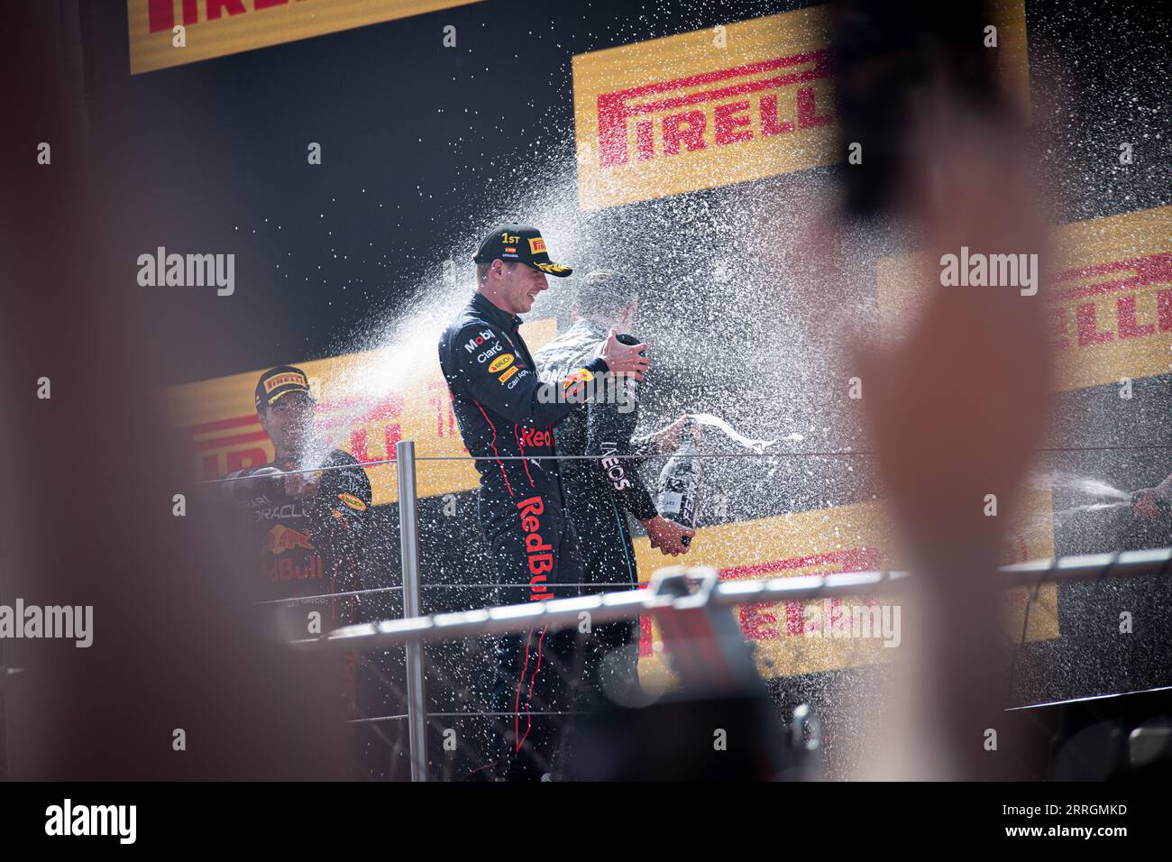 George Russell, Max Verstappen, and Sergio Perez in jubilant celebration, spraying champagne after their victories at the Spanish Grand Prix. Stock Photo