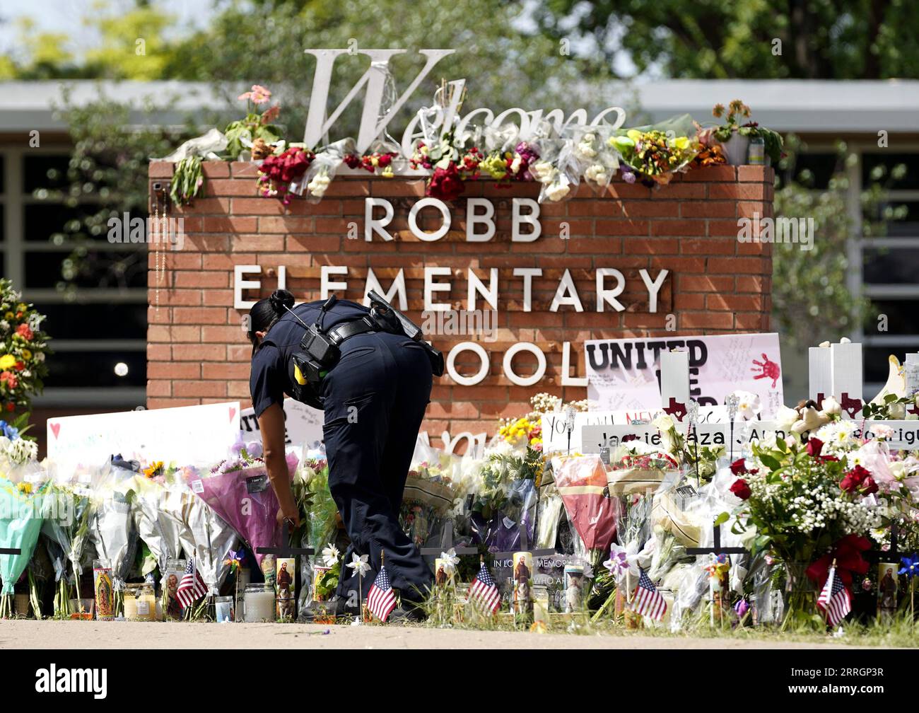 220528 -- UVALDE, May 28, 2022 -- A police officer lays flowers outside Robb Elementary School in the town of Uvalde, Texas, the United States, May 27, 2022. At least 19 children and two adults were killed in a shooting at Robb Elementary School in the town of Uvalde, Texas, on Tuesday.  U.S.-TEXAS-UVALDE-MASS SHOOTING-MOURNING WuxXiaoling PUBLICATIONxNOTxINxCHN Stock Photo