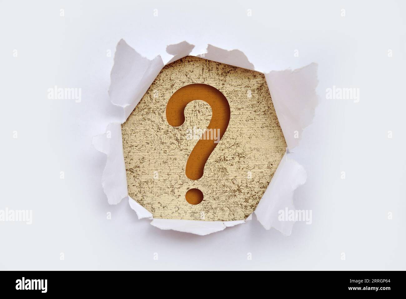 Torn out white paper with question mark symbol. White torn paper revealing question mark symbol on Pink paper. Stock Photo