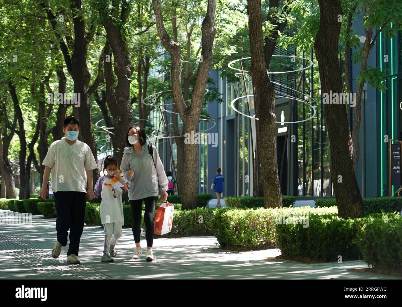 220529 -- BEIJING, May 29, 2022 -- People walk on a road in Sanlitun, a popular shopping area in Beijing, capital of China, May 29, 2022. Beijing saw no community transmission of COVID-19 in the city from Friday to 3 p.m. Sunday, an official told a press conference Sunday. The Chinese capital reported seven new locally transmitted COVID-19 infections from the end of Saturday to 3 p.m. Sunday, which were all among those quarantined for observation, said Liu Xiaofeng, deputy director of the Beijing Center for Disease Prevention and Control.  CHINA-BEIJING-COVID-19-PREVENTION AND CONTROLCN ChenxZ Stock Photo