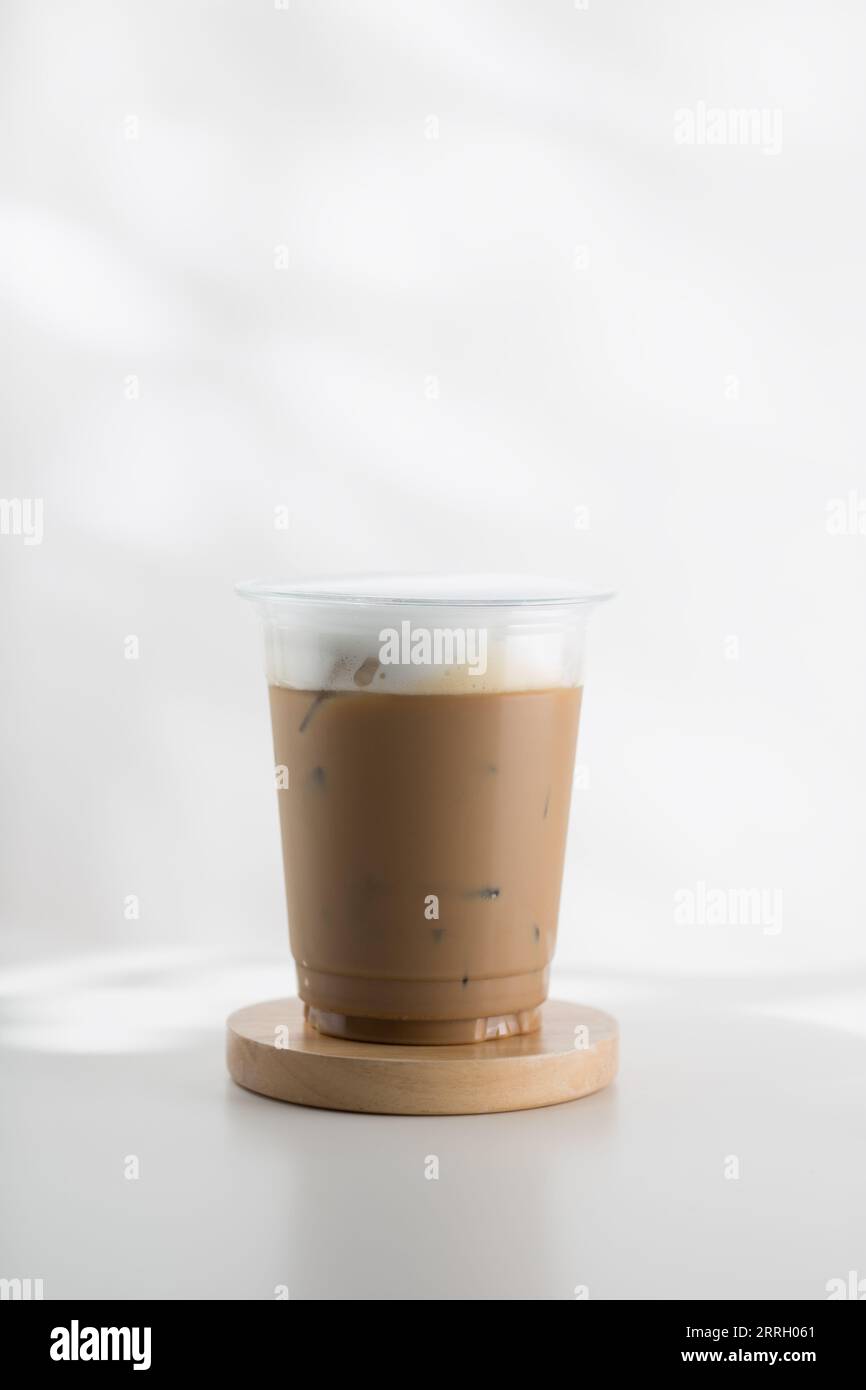 https://c8.alamy.com/comp/2RRH061/iced-cappuccino-in-a-plastic-glass-on-a-white-wooden-table-minimalist-style-picture-2RRH061.jpg