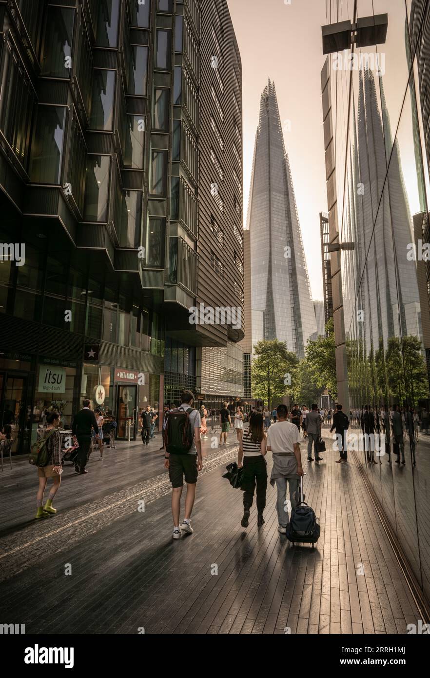 London, UK: People walking in More London, a modern business area in Southwark, London. The ...