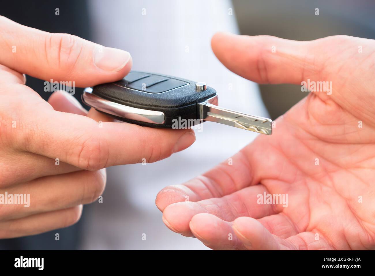 Closeup Of Valet's Hand Giving Car Key To Businessperson Stock Photo
