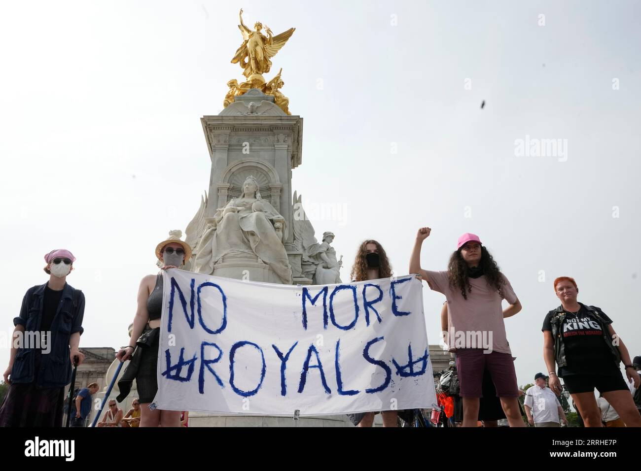 Anti Royal demonstrators stand on the Queen Victoria Memorial on the