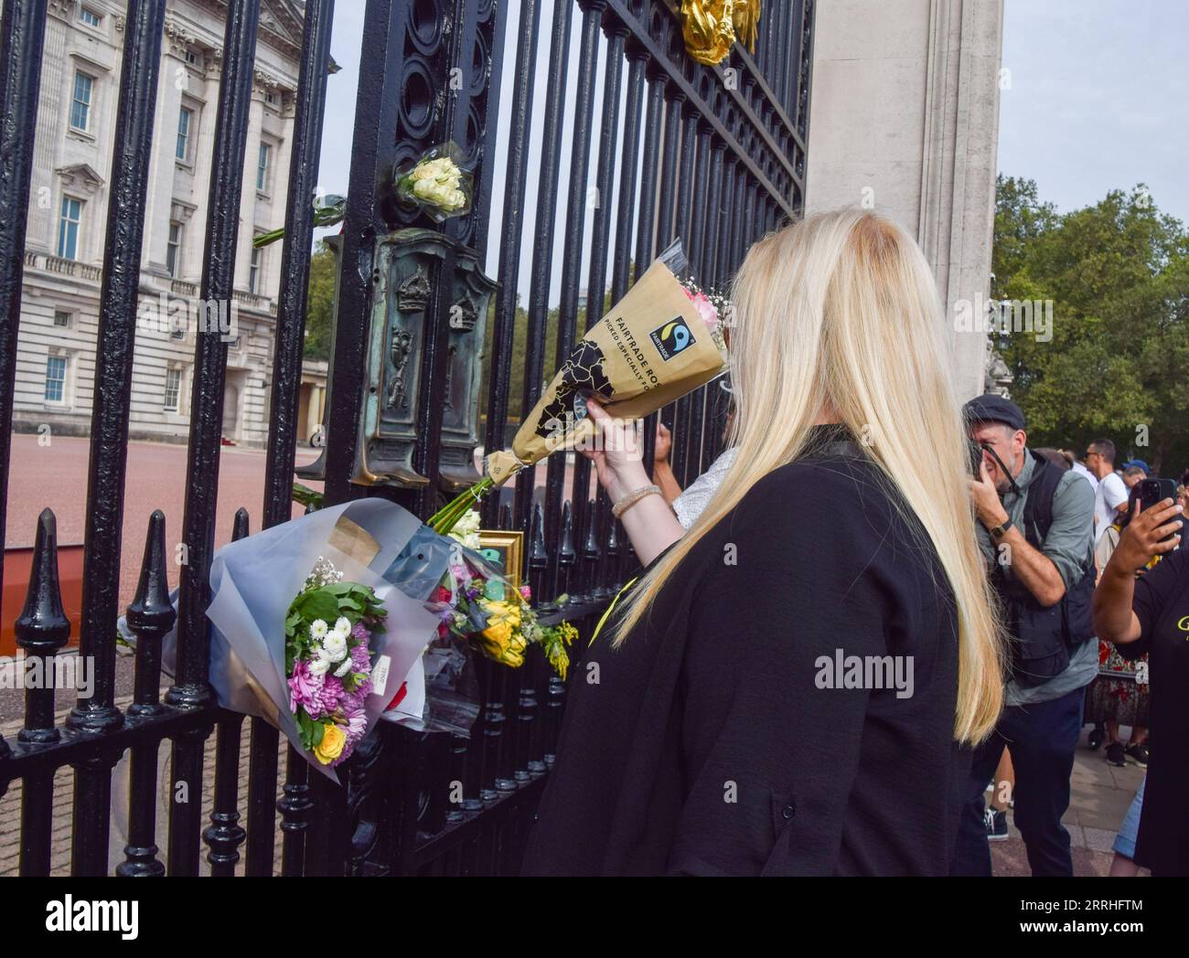 London, UK. 8th September 2023. A woman places flowers outside