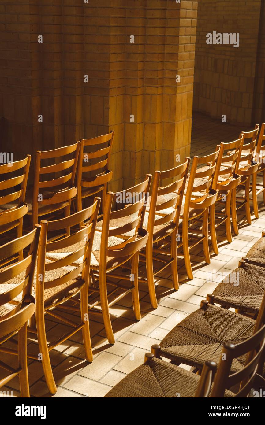 Sunbathed rows of wooden chairs in the Grundtvig's Church interior Stock Photo
