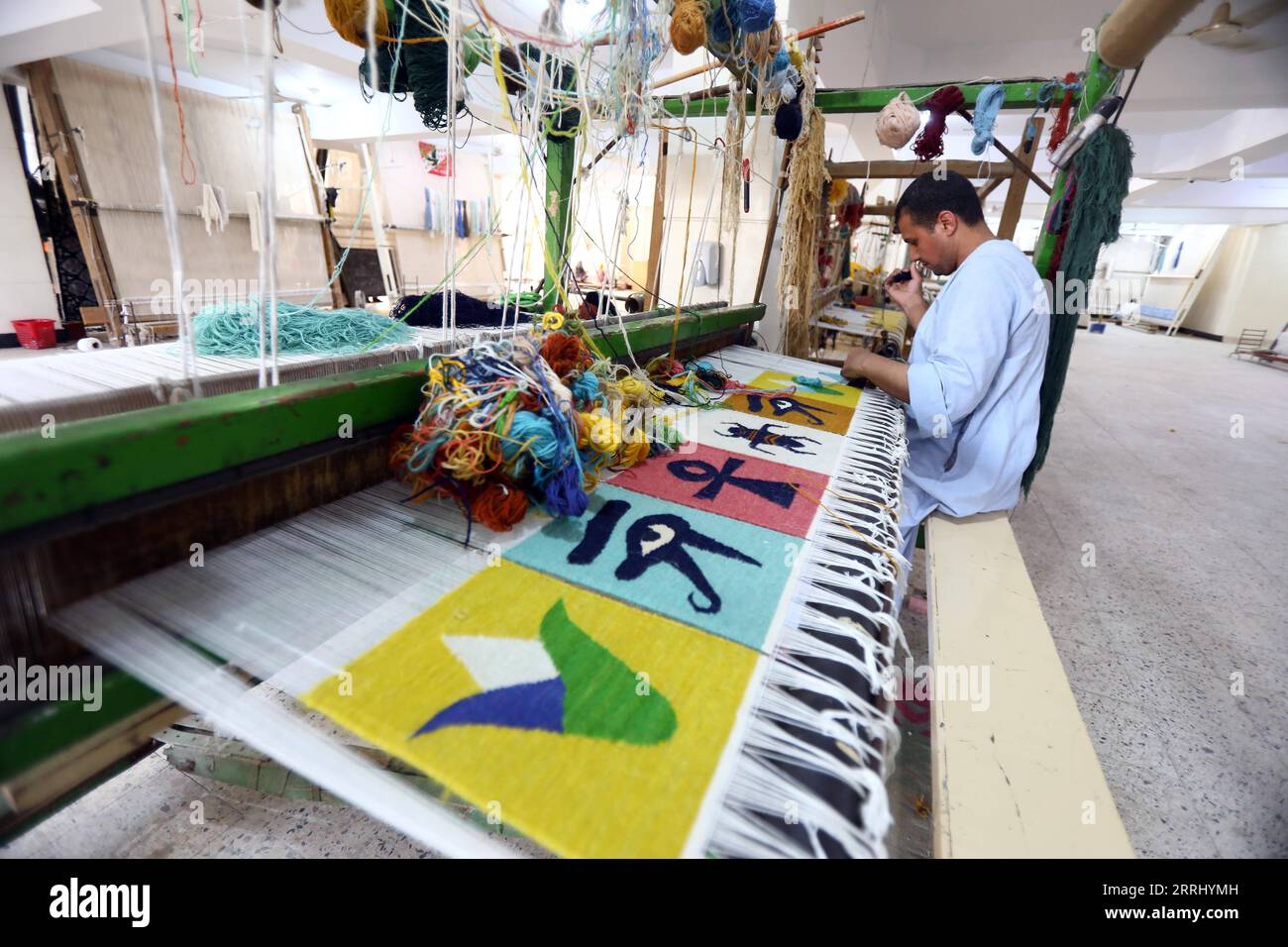 220710 GIZA, July 10, 2022 A man weaves a carpet at a weaving