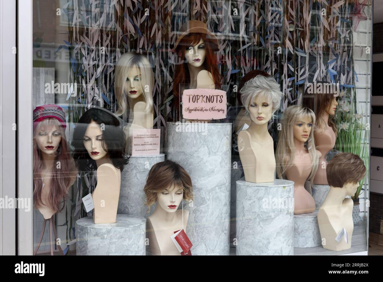 Hairdressers or Hairdresser Shop Window, Display Window or Store Window with Display of Mannequins or Dummies with Wigs and Topknots West Kirby E Stock Photo