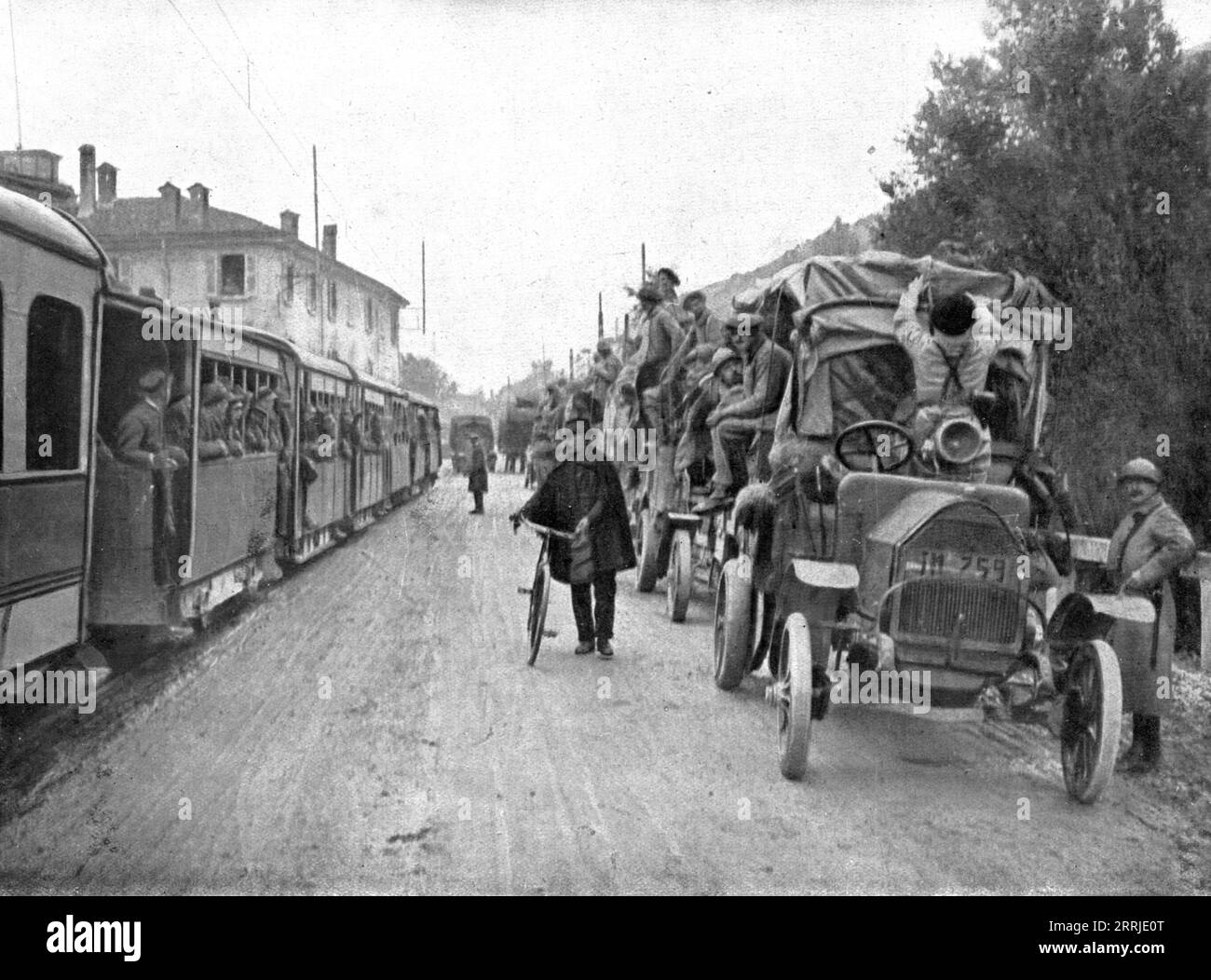 'French Troops in Italy; Two convoys on the road from Brescia to Verona: on the left, an electric train loaded with Italian troops; on the right, road-trucks transporting French troops', 1917. From &quot;L'Album de la Guerre 1914-1919, Volume 2&quot; [L'Illustration, Paris, 1924]. Stock Photo