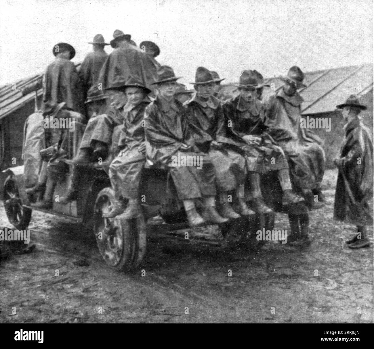 'L'Installation en France de L'Avant-Garde Americaine; Un groupe en manteau de pluie amen&#xe9; en camion', 1917. First World War: the American advance guard arrives in France; a group in raincoats arrives by truck. From &quot;L'Album de la Guerre 1914-1919, Volume 2&quot; [L'Illustration, Paris, 1924]. Stock Photo