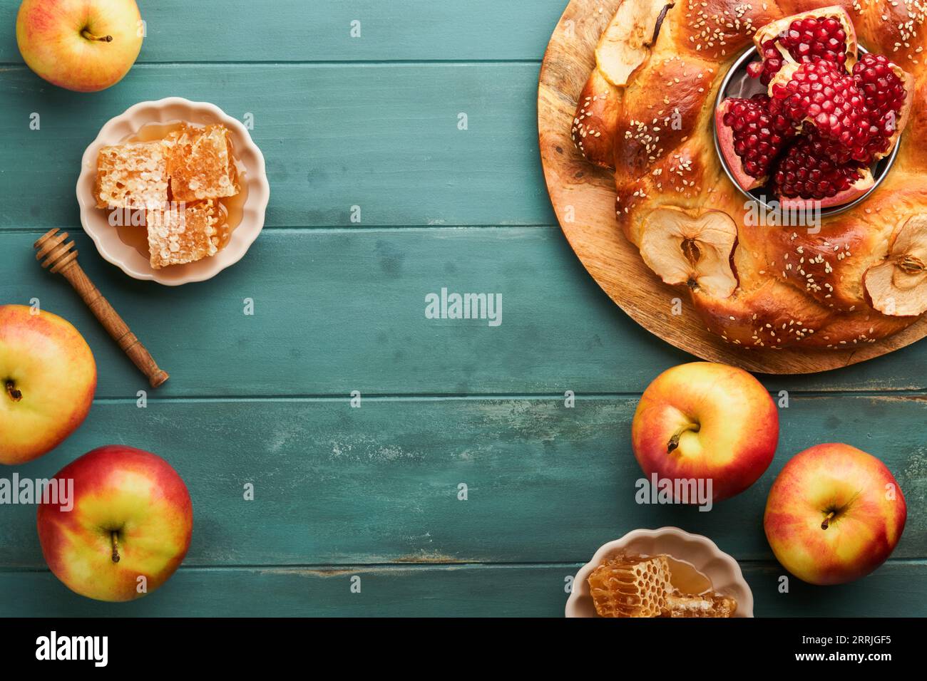Jewish Holidays - Rosh Hashanah or Rosh Hashana. Pomegranate, apples, honey and round challah on  old wooden blue table background. Jewish Autumn cele Stock Photo