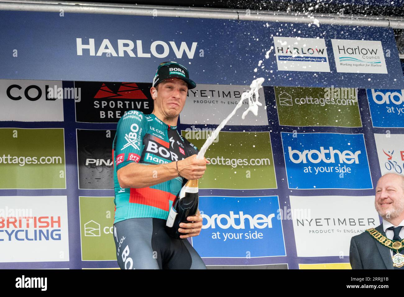 Harlow, Essex, UK. 8th Sep, 2023. The riders have raced from the start in Southend on Sea to the finish line in Harlow after 91 miles of competing through the Essex countryside. First across the line in a bunch sprint was Danny van Poppel of team Bora-Hansgrohe, celebrating his win by spraying champagne Stock Photo