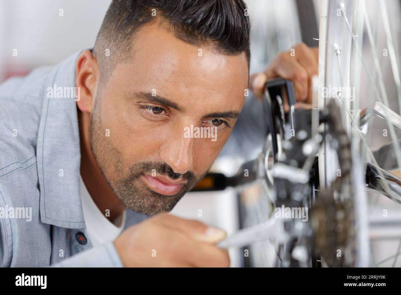man fixing pedals on a bicycle Stock Photo