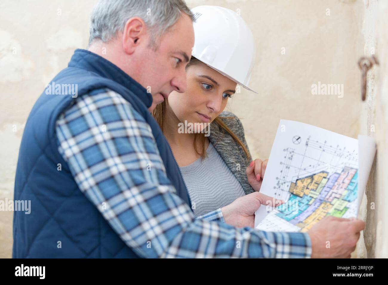 surveyors in discussion while looking at blueprints Stock Photo