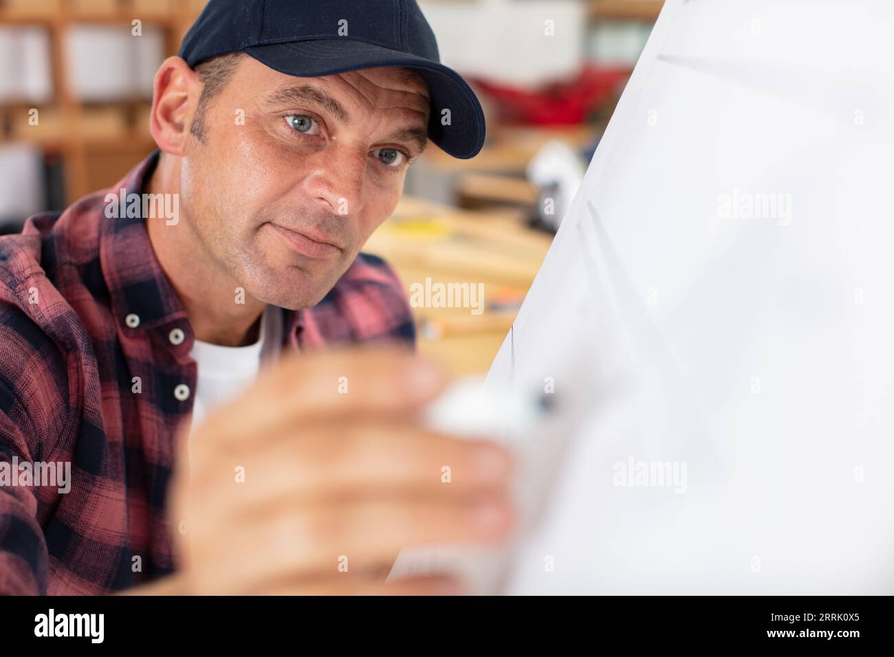 senior carpenter writing blueprints in his workshop Stock Photo - Alamy