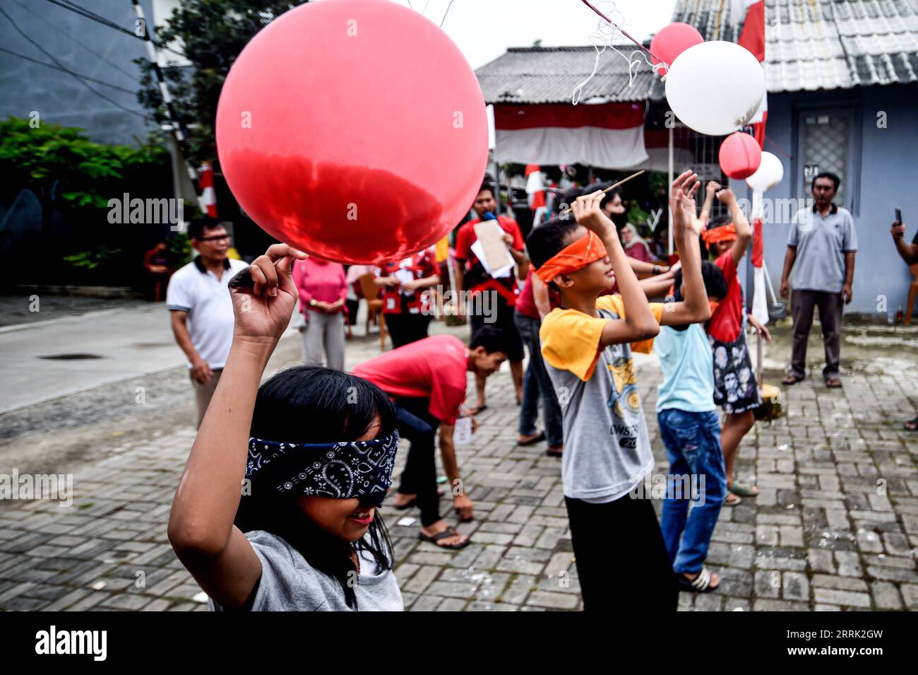 220817 -- SOUTH TANGERANG, Aug. 17, 2022 -- Children participate in a balloon piercing game during the 77th Independence Day celebration in South Tangerang, Banten Province, Indonesia, Aug. 17, 2022.  INDONESIA-SOUTH TANGERANG-INDEPENDENCE DAY-CELEBRATION AgungxKuncahyaxB. PUBLICATIONxNOTxINxCHN Stock Photo