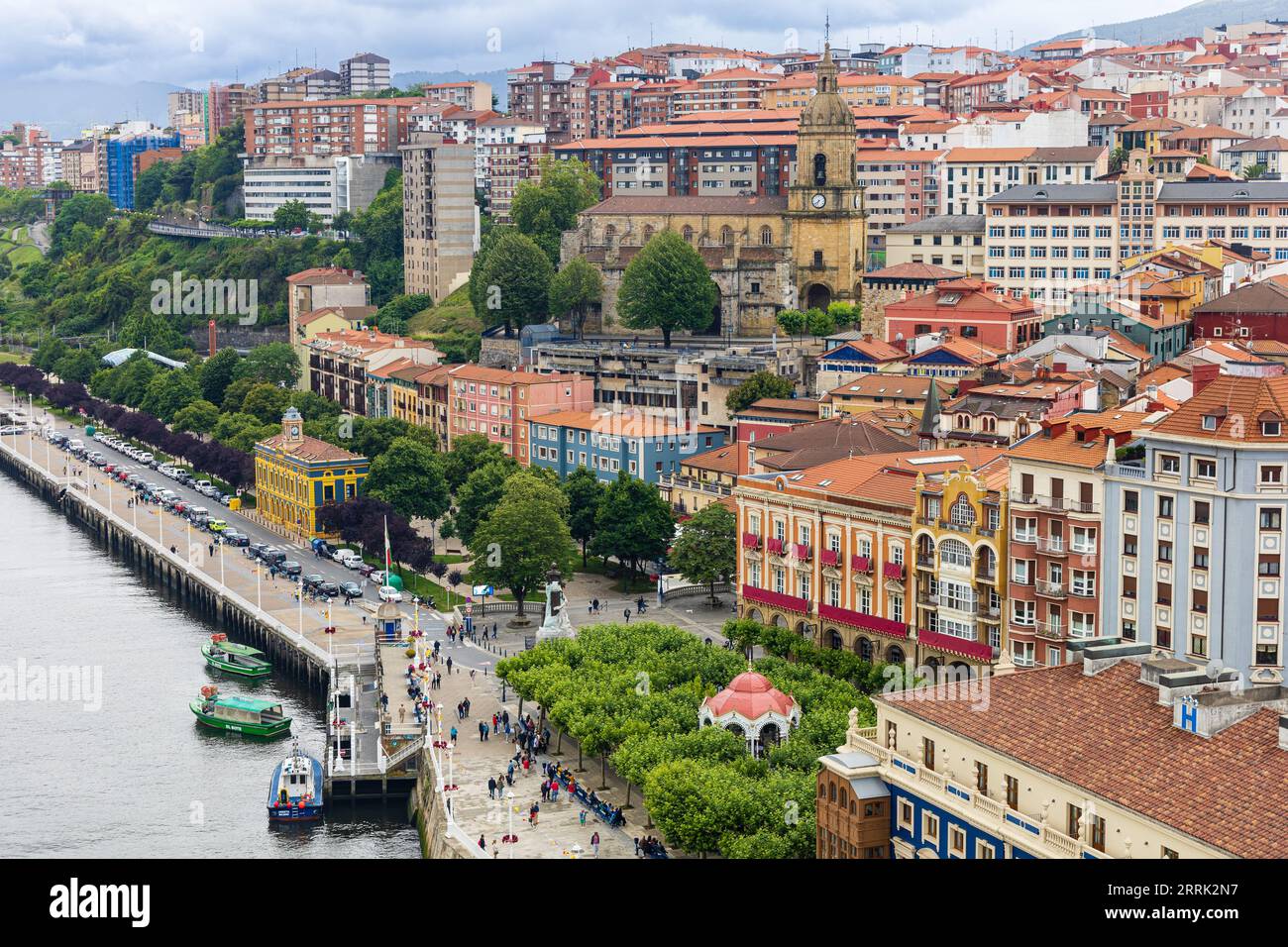 View of the Nervion river, the waterfront of Portugalete, Orube Plaza, and the Basilica of Santa Maria. Overcast day. Portugalete, Biscay, Spain Stock Photo