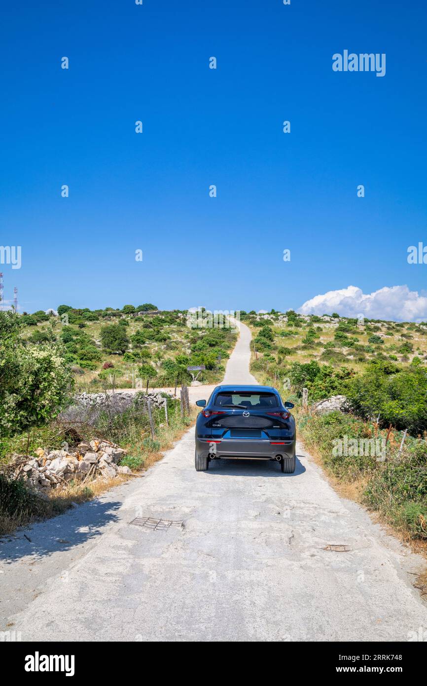 Europe, Croatia, Primorje-Gorski Kotar County, Mundanije, island of Rab, car crossover Mazda CX 30 on the rough dirt road of Kamenjak mountain Stock Photo