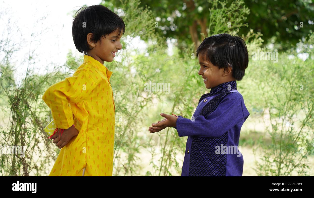 Hindu Brother and sister in ethnic wear holding Indian sweets and gift