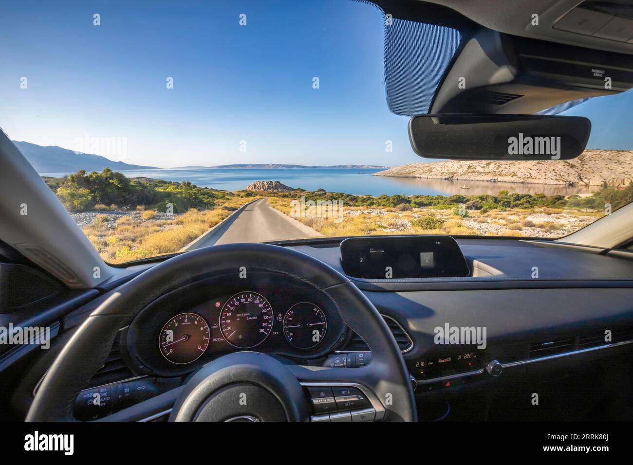 Europe, Croatia, Primorje-Gorski Kotar County, Rab island, view from inside the car driving towards the sea on a narrow access road Stock Photo