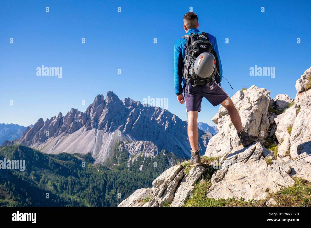 Italy, Veneto, Province of Belluno, San Nicolò di Comelico, young hiker approaching the D'Ambros via ferrata on the Pitturina ridge, Crode dei Longerin in the background Stock Photo