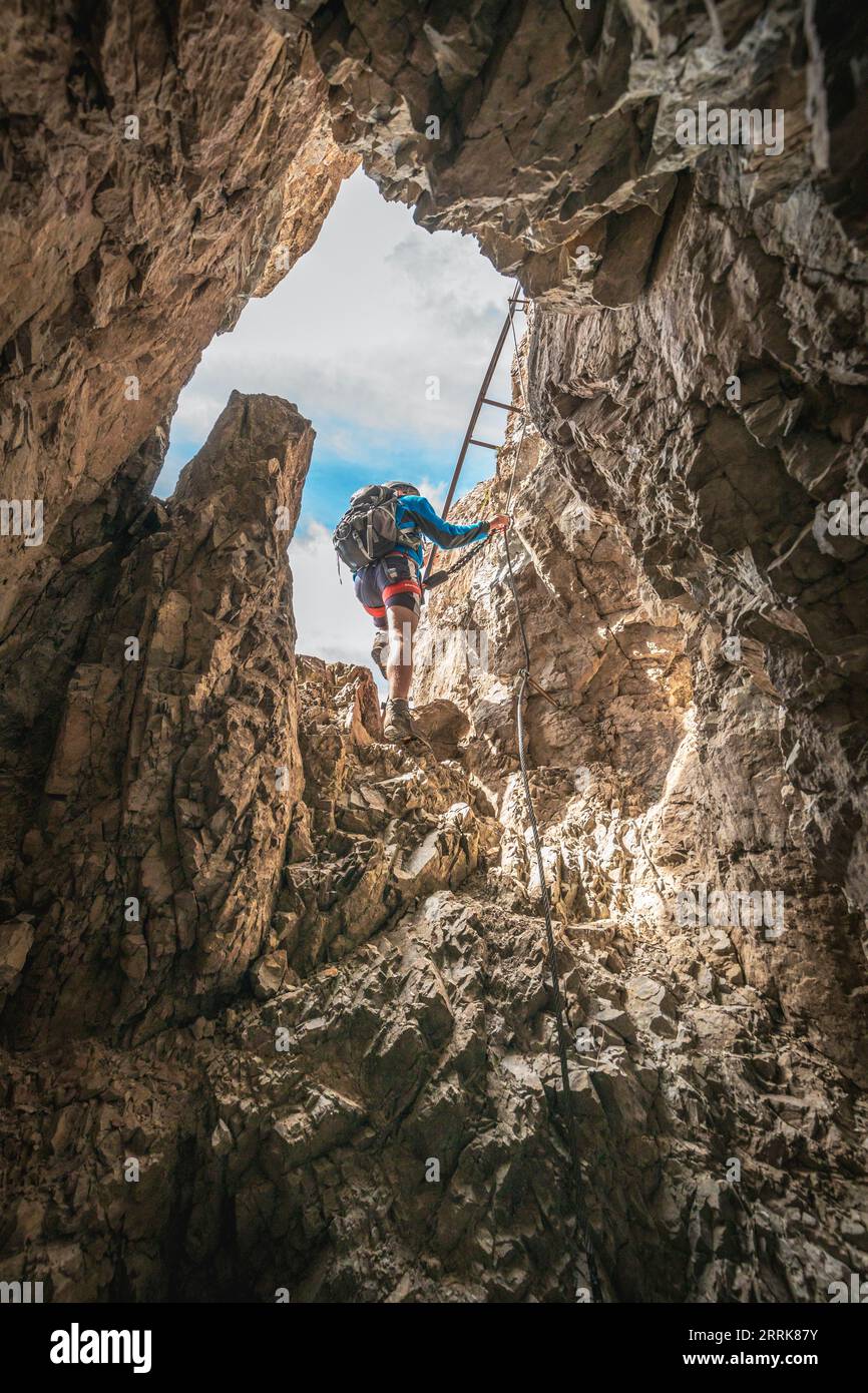Italy, Veneto, Province of Belluno, San Nicolò di Comelico, young hiker climbs along the D'Ambros via ferrata on the Pitturina crest, Carnic Alps border between Italy and Austria Stock Photo