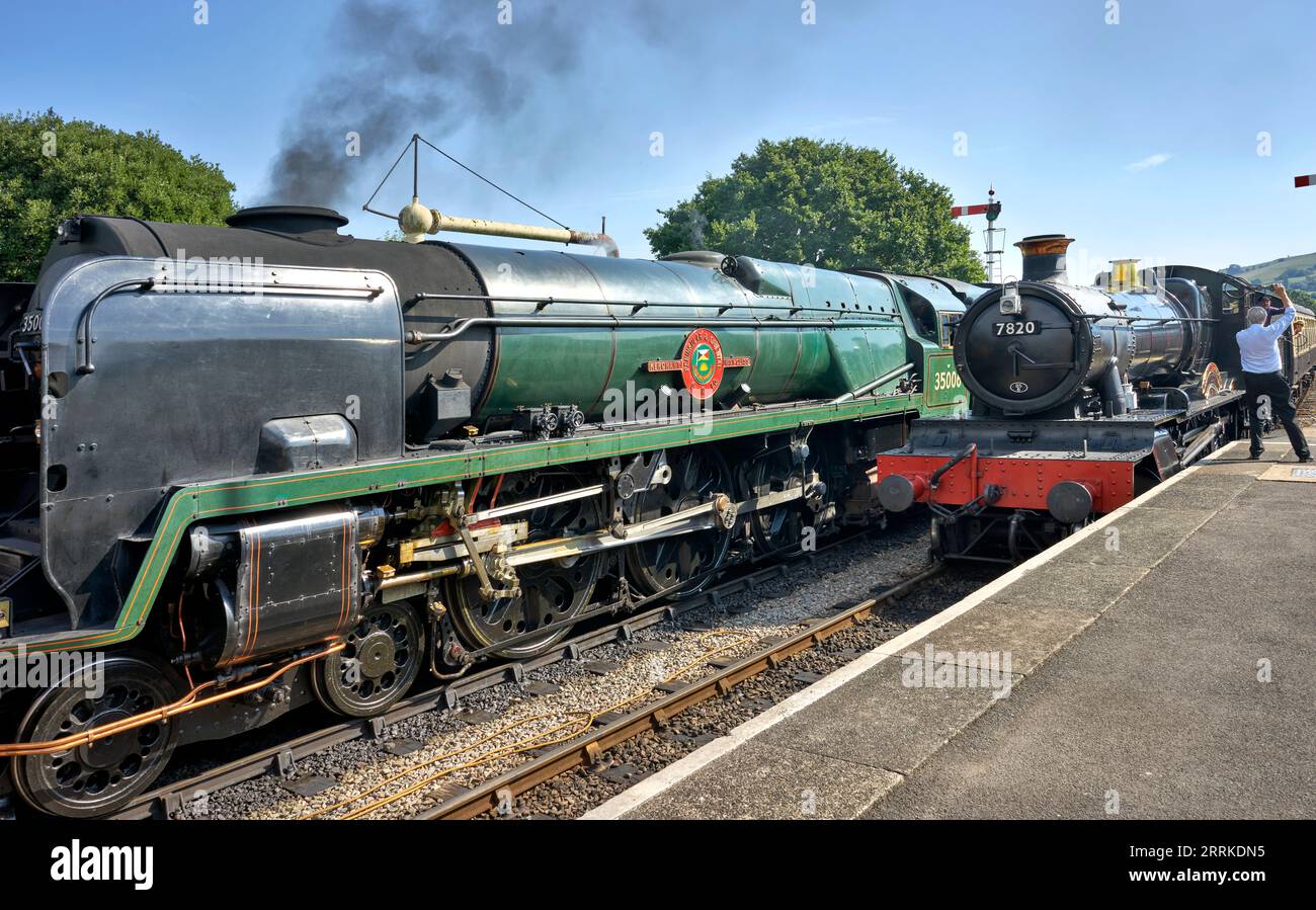 Two steam trains at the GWR preserved train station platform Winchcombe Gloucestershire England UK. No 7820 Dinmore Manor and No 35006 P7O Navy Class Stock Photo