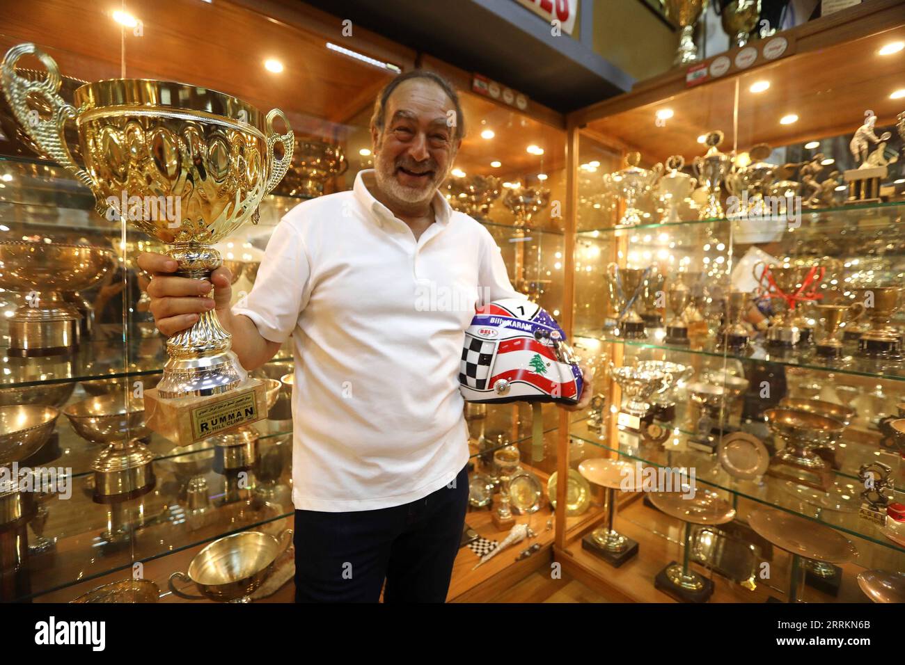 220915 -- BEIRUT, Sept. 15, 2022 -- Nabil Karam poses for photos with trophies he won in car races at the Billy Karam Museum in Zouk Mosbeh, Lebanon, Sept. 12, 2022. Lebanese race car champion Nabil Karam started his hobby of collecting mini sports cars 30 years ago. Today, the 65-year-old man has collected around 50,000 car miniatures from around the world. TO GO WITH Feature: Lebanese racer turns hobby into car museum  LEBANON-MUSEUM-MODEL CARS BilalxJawich PUBLICATIONxNOTxINxCHN Stock Photo