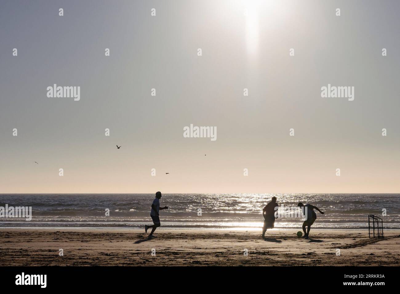 Soccer player on sandy beach by the sea Stock Photo
