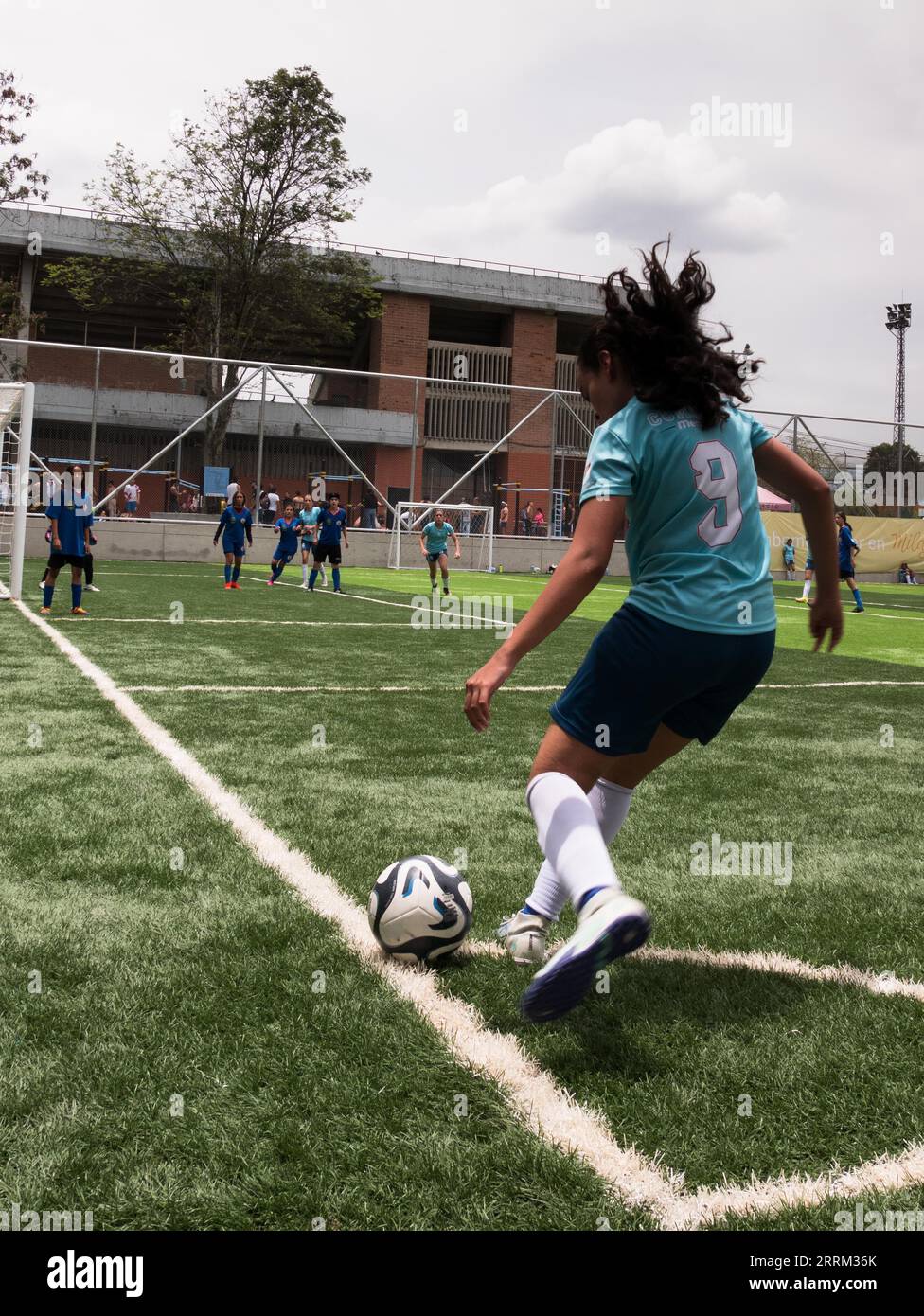Envigado - 22 april 2023: Girl performing a corner kick during a school sports tournament Stock Photo