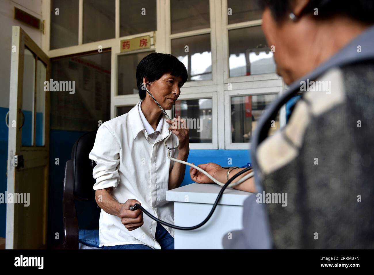 220929 -- TAIYUAN, Sept. 29, 2022 -- Undated file photo shows Liu Guizhen measuring blood pressure for a villager at a clinic in Duanjiawan Village, Daixian County of north China s Shanxi Province. TO GO WITH Profile: A Party secretary who changed her village  CHINA-TAIYUAN-CPC-NATIONAL CONGRESS DELEGATE-LIU GUIZHEN CN ZhanxYan PUBLICATIONxNOTxINxCHN Stock Photo