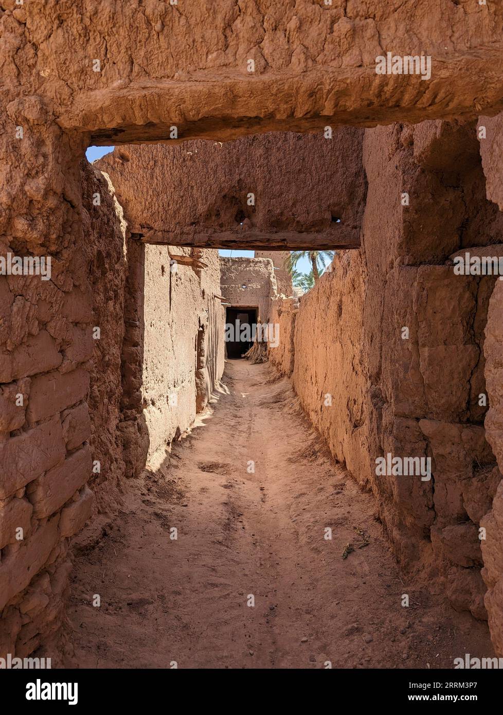 Typical abandoned alleyway surrounded by old clay walls in a little village somewhere in the Draa valley Stock Photo