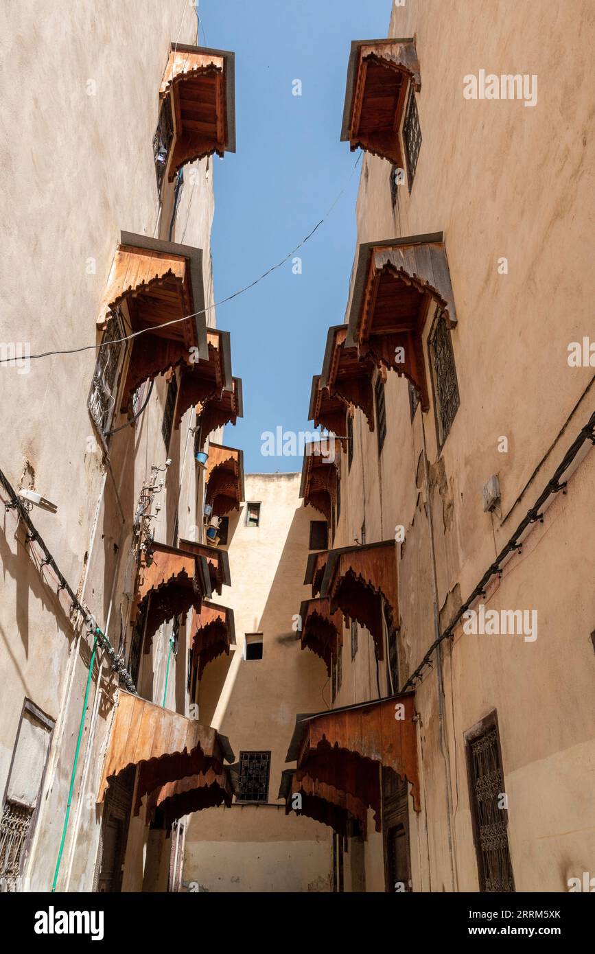 Many wooden window awnings at two residential buildings in Fes, seen from the side, Morocco Stock Photo